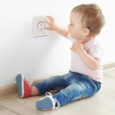 Enfant curieux assis côté cache prise