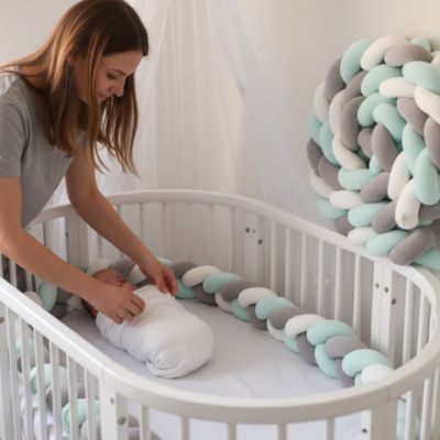 Maman emmaillotant bébé tresse de lit vert menthe gris blanc