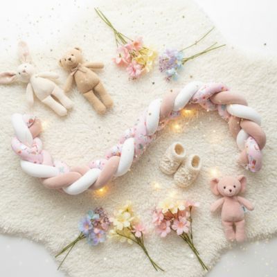 Tresse de lit bebe rose sur tapis peluches fleurs déco